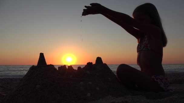 キッズビルディング城ビーチで日没、子供は海辺のサンズで遊ぶ、女の子は夏休みの日没で海岸で夏休みを楽しむ — ストック動画