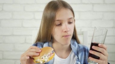 Fast food yiyen çocuk, restoranda hamburger yiyen çocuk, çizburgerli aç sarışın kız.