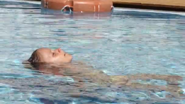 Ragazzo che nuota in piscina, Bambino sorridente, Bionda Ritratto di ragazza che gode le vacanze estive — Video Stock