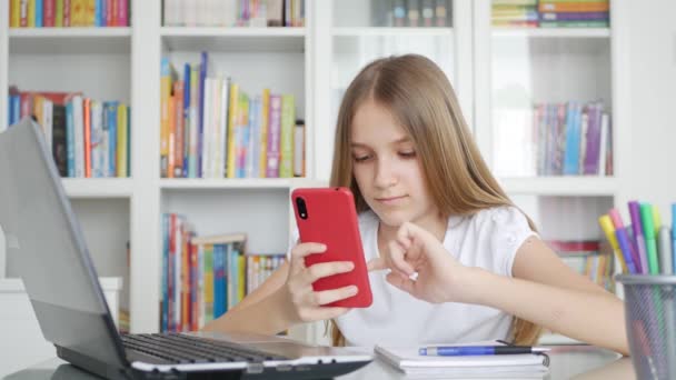 Παιδί που χρησιμοποιεί Smartphone Μελετώντας σε Video Conferencing, Παιδική Εκπαίδευση, Γράφοντας στη Βιβλιοθήκη, Schoolgirl Συνομιλία, Online Εκπαίδευση — Αρχείο Βίντεο