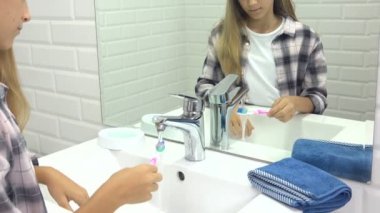 Banyoda bebek dişlerini fırçalayan çocuk diş fırçası kullanan çocuk, aynadaki sarışın kız.