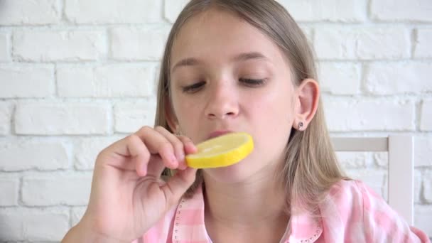 Kind isst Zitrone, Kind frisst Früchte, junges Mädchen beim Frühstück in der Küche — Stockvideo