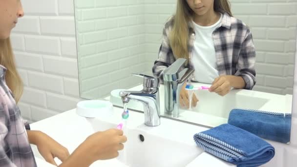 Kind putzt Babyzähne im Badezimmer, Kind wäscht sich mit Zahnbürste, Blondes Mädchen im Spiegel — Stockvideo