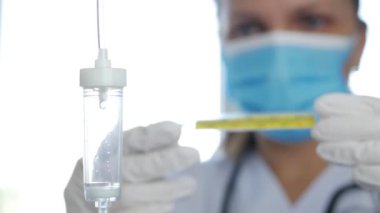 Doktor 'un Koruyucu Maske ve Ameliyat Eldiveni Giydiği Bulanık Görüntü İnsan Vücut Sıcaklığı İçin Termometreyi Kullanarak Hastane Odası' nda
