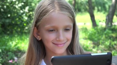Çocuk parkta tablet sallıyor, Sarışın Çocuk internette Smartphone 'da internette geziniyor, Genç kız doğada dinleniyor.