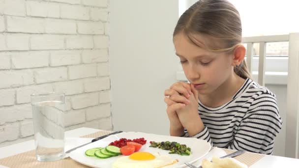 Kind betet vor dem Frühstück in der Küche, Kind bereitet sich auf Mahlzeit vor, Christmädchen religiös zu Hause — Stockvideo