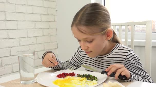 Kid äter frukost i köket, barn äter stekta ägg, tonåring flicka njuter av grönsaker, grönska hälsosam mat — Stockvideo