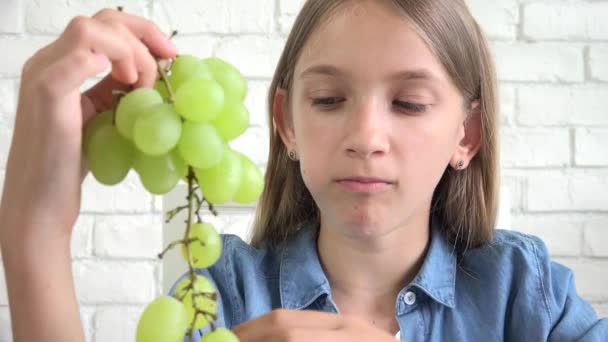 Niño comiendo uvas, Niño come frutas frescas, Joven adolescente en el desayuno en la cocina — Vídeo de stock