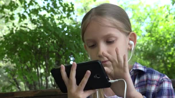 Kid Playing Tablet at Playground in Park, Girl Browsing Internet, Child use Smartphone on Bench Outdoor in Nature — Stock Video