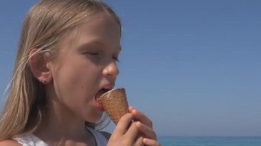 Gün batımında sahilde dondurma yiyen çocuk, sahilde oynayan çocuk, yaz tatilinde okyanusta dalgaları seyreden sarışın kız.