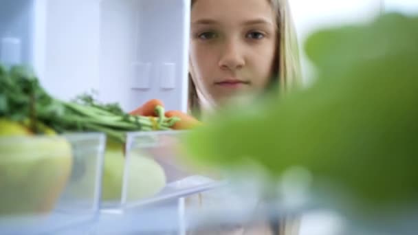 Gyerek eszik szőlőt a hűtőből, éhes gyermek eszik friss gyümölcsöt a hűtőszekrényben, fiatal lány a diéta, egészséges zöldségek a konyhában — Stock videók