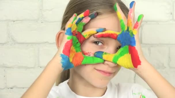Gyerek játék festett kéz, gyermek keres a kamerába, mosolygós iskola szőke lány arc, otthoni projekt, gyermeknevelés — Stock videók