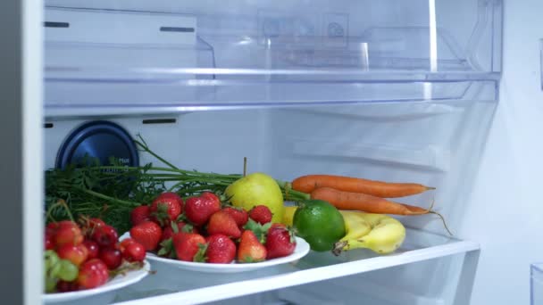 Niño comiendo manzana del refrigerador, el niño hambriento come frutas frescas en el refrigerador, Chica joven a dieta, Mujer de comida saludable en la cocina — Vídeo de stock