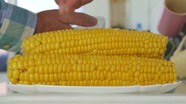 Man matlagning koka majs för att äta i köket, kokta grönsaker hemma, äta kokt majs vid lunch, hälsosam spannmål mat — Stockvideo