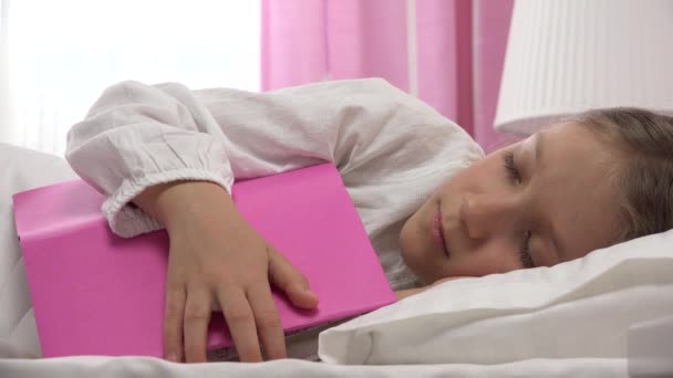 Niña durmiendo después de leer un libro, niña durmiendo en su cama después de estudiar, chica rubia aprendiendo en el dormitorio en casa — Vídeos de Stock