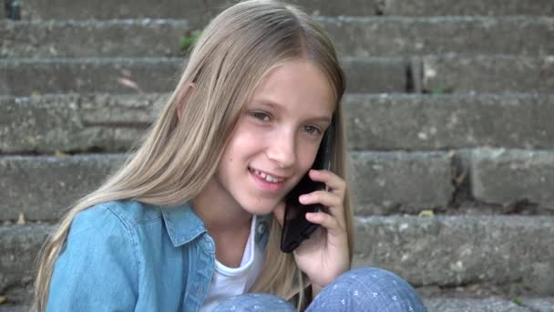 Child Talking on Smartphone, Adolescent Using Smart Phone, Teenager Blonde Girl Playing Outdoor in Park — Stock Video