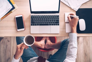 Çizgi roman modern ofis masa üstü dizüstü bilgisayar klavye görüntüsü. İş adamı notlar yazıyor, kahve içiyor ve masanın altında ayaklarının üzerinde süzülüyor. Dünya çapında karantina zaman kavramında mesafe çalışması