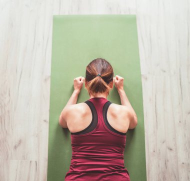 Chaturanga Dandasana yoga pozisyonu almış sportif sağlıklı bir kadın, nefes egzersizleri yapıyor, dizüstü bilgisayarda yoga dersleri izliyor. Sağlıklı insanlar ve motivasyon kavramı.
