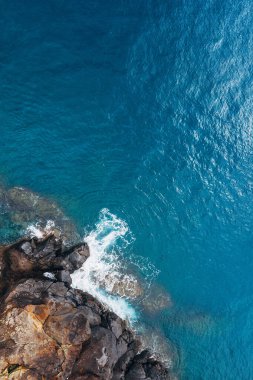 Turkuaz Atlantik okyanus dalgalarının en üst hava manzarası Portekiz Madera adasındaki kayalara çarpıyor..