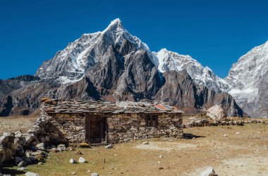 Nepal 'in Khumbu bölgesindeki otantik Tibet yerleşimi ve taş çit manzaralı muhteşem Taboche dağı 6501 metre arka planda. Uzak seyahat mücevherleri konsept resmi.