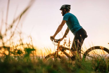 Erkek motorcu şehrin tepesinde gün batımıyla karşılaşır. Aktif spor insanları konsepti imajı