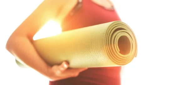 年轻女子举着滚动橡胶体操垫开始晨练瑜伽 积极的人和健康的生活方式概念 — 图库照片