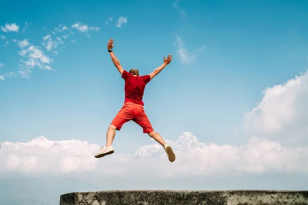 Homem Feliz Vestido Vermelho Pulando Sobre Nuvens Com Montanhas Cordilheira — Fotografia de Stock