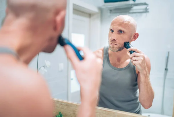 Bald Man Fixing His Beard Looking Bathroom Mirror Using Electric — Stock Photo, Image