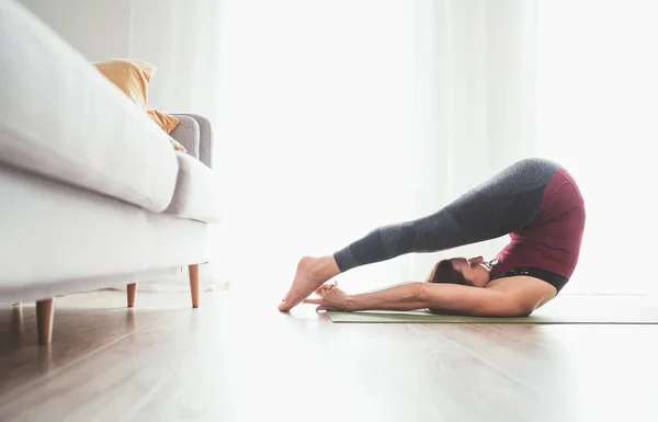 Jovem Mulher Graciosa Desfrutando Exercícios Ioga Matinal Fazendo Halasana Posar — Fotografia de Stock