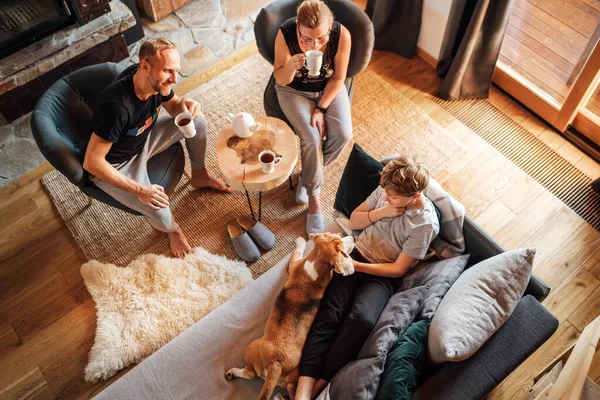 居心地の良い家族のティータイム 自宅のリビングルームで父 男の子快適なソファに横たわって 彼らのビーグル犬と笑顔を撫でます 平和な家族の瞬間のコンセプトイメージ — ストック写真