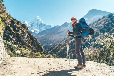 Genç yürüyüşçü kadın Dingboche, Nepal yakınlarındaki Everest Ana Kamp rotası boyunca vadide yürüyüş yaparken fren yapıyor. Ama Dablam 6812 metre arka planda. Etkin tatil kavramı.