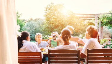 Büyük çok nesilli aile akşam yemeği yer. Bahçede bir yaz akşamı