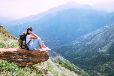 Turist kadın Ella, Sri Lanka, Little Adam Peak 'teki dağların ve vadilerin güzel manzarasının tadını çıkarıyor.