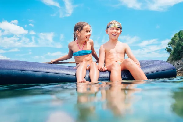 姐姐和哥哥在海里游泳时 坐在充气床垫上玩得很开心 粗心的童年时光形象 — 图库照片