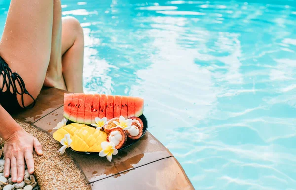 Mulher Vestida Maiô Sentado Lado Piscina Com Prato Frutas Tropicais — Fotografia de Stock