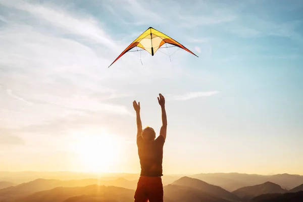 Uomo Inizia Volare Aquilone Luminoso Nel Cielo Del Tramonto Sopra — Foto Stock