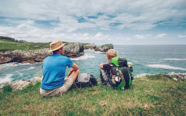 父亲和儿子的背包客在岩石的海滨休息 — 图库照片