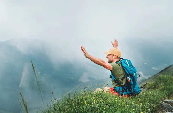 背包客可以休息一下 在多雾的多云天气山脉边漫步 享受多云的山谷底部的美景 他把胳膊举过头顶 积极运动背包健康生活方式的概念 — 图库照片