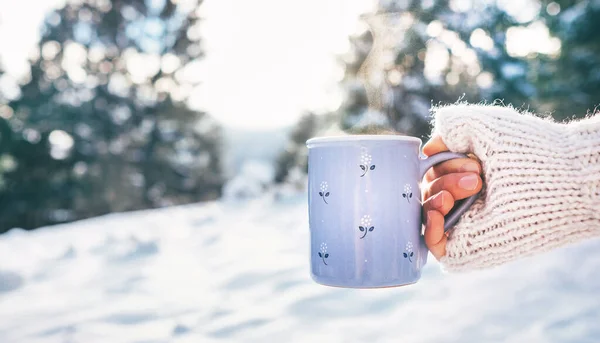 女人手里拿着一杯热饮 冬林雪地 阳光灿烂的景象 — 图库照片
