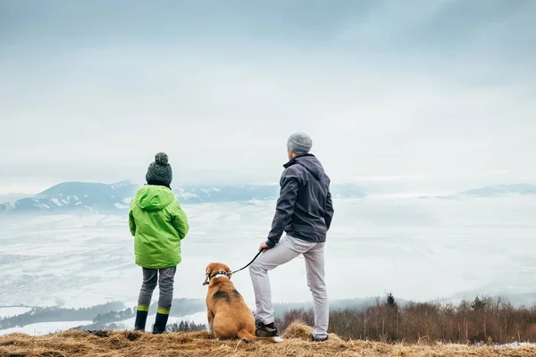 Vader Met Zoon Hond Kijken Samen Winter Berg Stad Panorame — Stockfoto