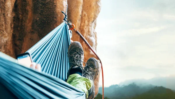 垂直崖の壁にハンモックで休むクライマー — ストック写真