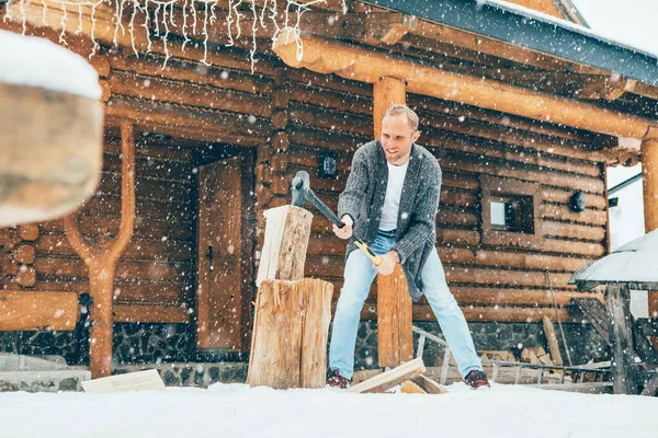 人们在雪地的院子里砍柴 找一个有厚厚的雪片背景的房子生火 冬季乡村假日的概念形象 — 图库照片