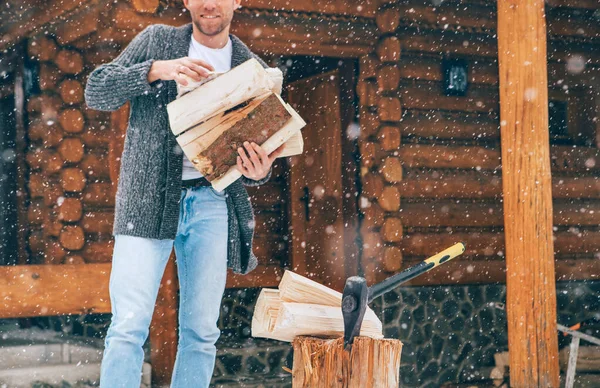 豪雪の背景を持つ家の暖炉のために雪の庭で木を切る男 冬の田舎の休日のコンセプトイメージ — ストック写真