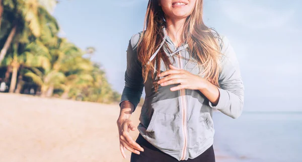 Uśmiechnięta Młoda Długowłosa Kobieta Uprawia Jogging Nad Morzem — Zdjęcie stockowe