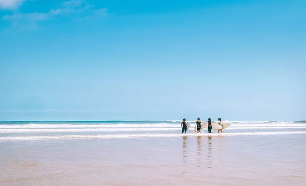 团体冲浪女孩与板停留在海上冲浪线 并准备进入水中 永远不会结束夏季冲浪的概念形象 — 图库照片
