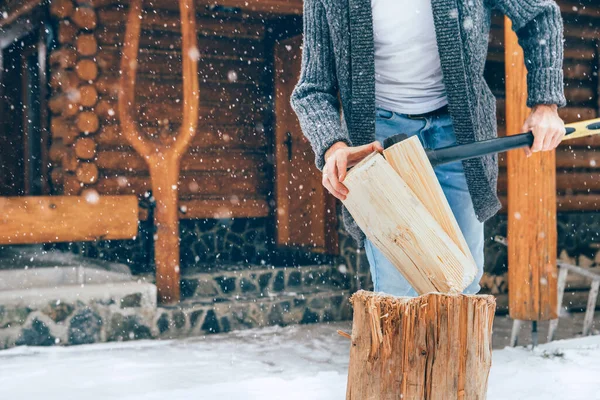 豪雪の背景を持つ家の暖炉のために雪の庭で木を切る男 冬の田舎の休日のコンセプトイメージ — ストック写真