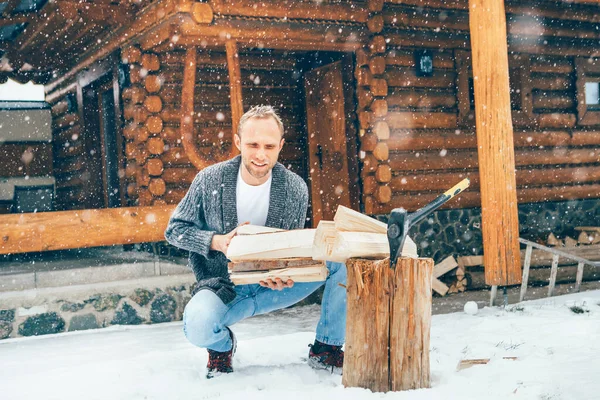 豪雪の背景を持つ家の暖炉のために雪の庭で木を切る男 冬の田舎の休日のコンセプトイメージ — ストック写真