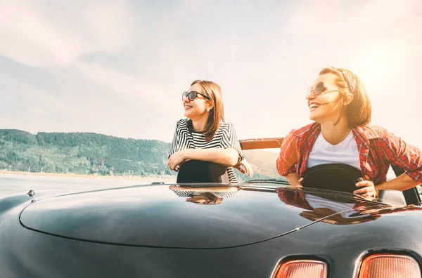 カブリオレで旅をする2人の女性の友人は 山の風景を楽しむためにストップブレーキを持っています — ストック写真
