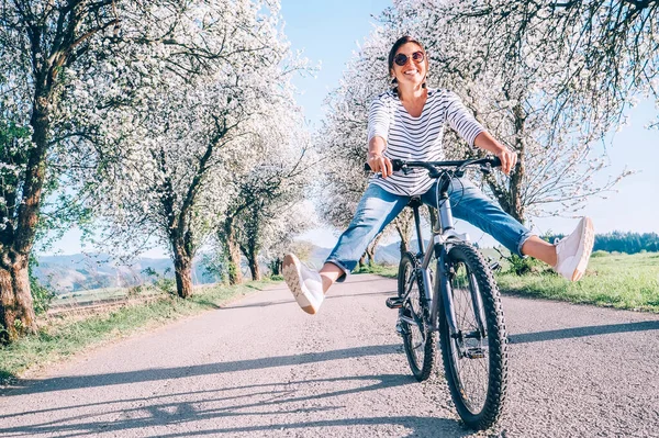 Szczęśliwa Uśmiechnięta Kobieta Radośnie Rozkłada Nogi Rowerze Wiejskiej Drodze Pod — Zdjęcie stockowe