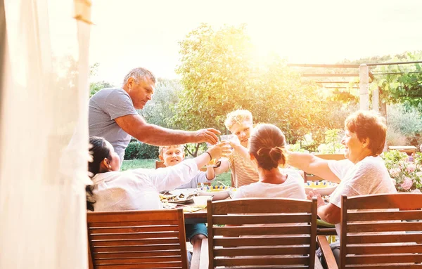 夏の庭で3世代1家族が夕食を持っている — ストック写真